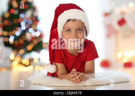 Carino ragazzo a casa a Santa cappello Foto Stock