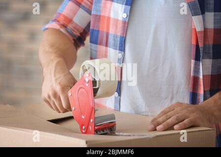 Scatola da imballaggio per giovani a casa, primo piano. Concetto di spostamento della casa Foto Stock
