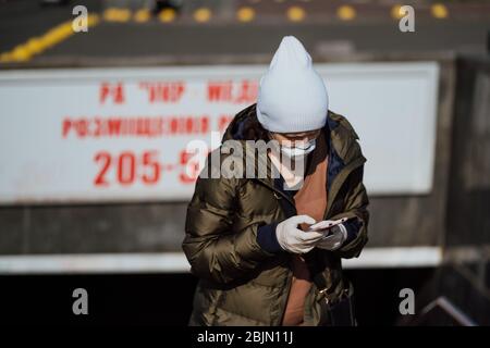 Kiev, Ucraina, 28 marzo 2020, UNA donna esce dalla metropolitana con un telefono in mano Foto Stock