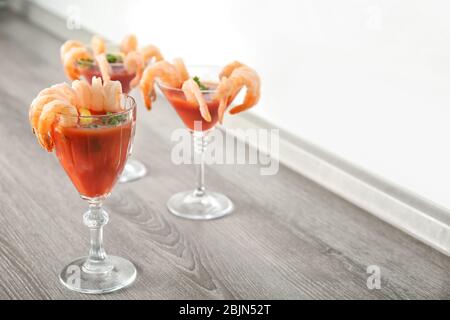 Bicchieri con cocktail di gamberi e salsa di pomodoro sul tavolo Foto Stock