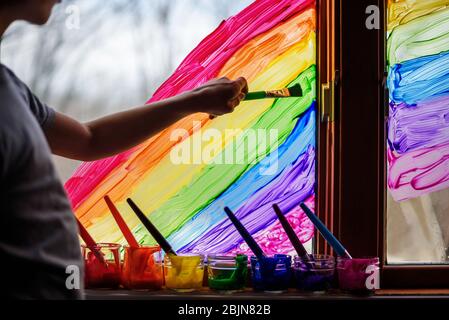 Ragazzo che dipinge un arcobaleno su una finestra, USA Foto Stock