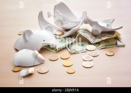 Banca di piggy rotta con soldi su sfondo chiaro Foto Stock