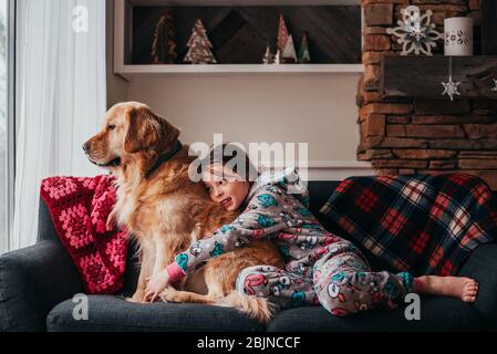 Ragazza seduta su un divano con il suo cane Foto Stock