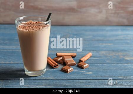 Vetro con shake di proteine di cioccolato su tavolo di legno Foto Stock