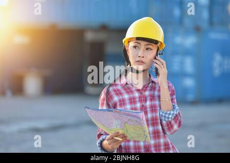 Ispettore presso un deposito container che parla al telefono, Thailandia Foto Stock