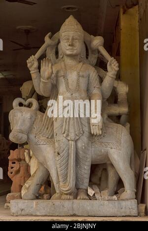 Una statua in pietra scolpita effigia di un Dio indù in piedi all'ingresso di un negozio che vende statue a Delhi Foto Stock