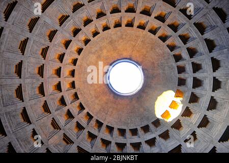 Guardando verso l'alto nella cupola in pietra scolpita del Pantheon con lucernario centrale dal basso in una vista dettagliata a cornice completa Foto Stock