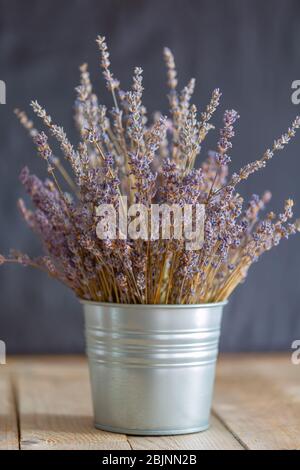 Bouquet di lavanda in ambiente rustico decorativo, tavolo in legno sfondo grigio Foto Stock