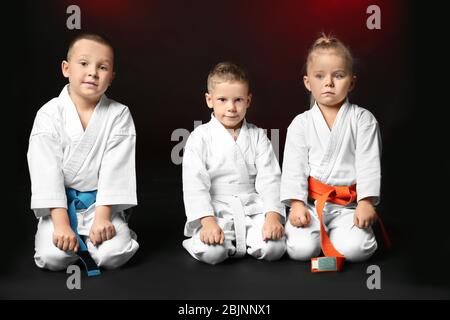 Bambini piccoli in carategi su sfondo scuro Foto Stock