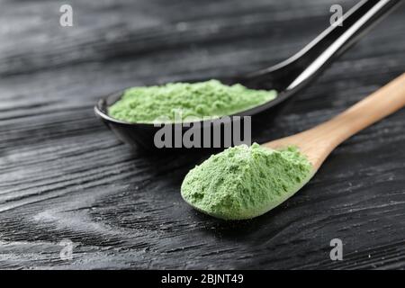 Polvere di erba di grano in cucchiai, primo piano Foto Stock