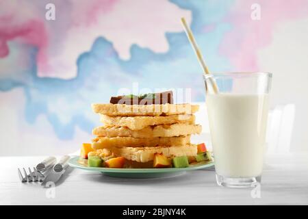 Piatto con deliziosi waffle alla cannella sul tavolo Foto Stock