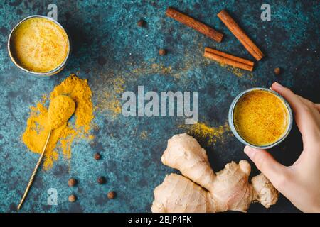 Vista dall'alto del latte curcuma, zenzero, cannella e allspezia. Bevanda immune e sanitaria. Foto Stock