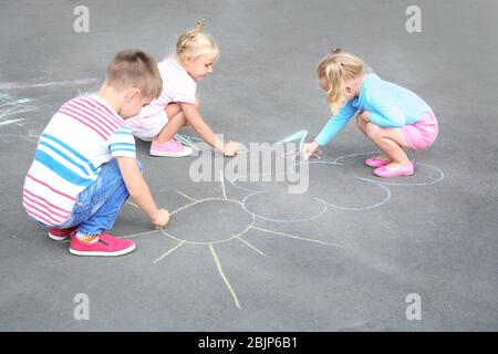 Carino figlioli disegno con gesso su asfalto Foto Stock