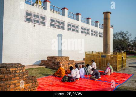 I pellegrini tengono un rituale serale di adorare il Buddha vicino al Tempio Maya Devi, Lumbini, Nepal. Lumbini è uno dei siti spirituali più buddisti al mondo e il luogo di nascita di Siddhartha Gautama, il fondatore del buddismo. La zona monastica Lumbini ha un certo numero di monasteri e templi costruiti da organizzazioni buddiste di vari paesi, sono stati completati o sono ancora in costruzione. Lumbini è stato reso Patrimonio dell'Umanità dall'UNESCO nel 1997. Foto Stock