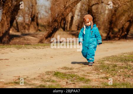 Un bambino triste ritorna a casa dalla foresta lungo un percorso forestale Foto Stock