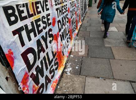Londra, Regno Unito. 30 Aprile 2020. La gente cammina davanti a manifesti che incoraggiano la gente ad avere fede durante l'epidemia di coronavirus a Londra, in Gran Bretagna, il 30 aprile 2020. Credit: Han Yan/Xinhua/Alamy Live News Foto Stock