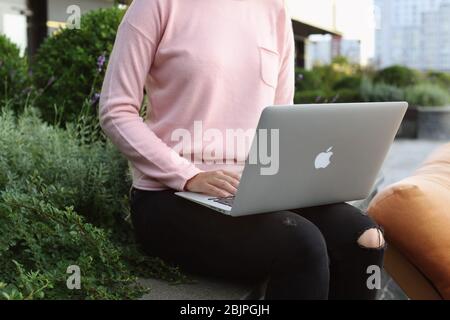 KIEV, UCRAINA - 25 SETTEMBRE 2017: Giovane donna con Apple MacBook Air in ginocchio Foto Stock