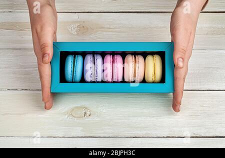 Scatola per mani femmina con macaroon Foto Stock
