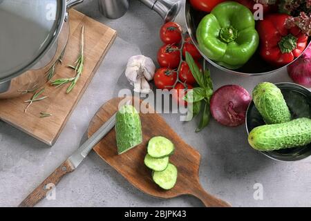 Composizione con utensili da cucina e verdure in tavola Foto Stock