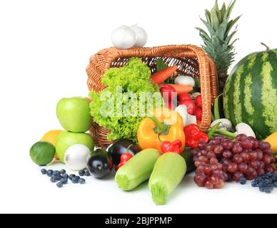 Cesto di vimini con frutta e verdura diverse su sfondo bianco Foto Stock