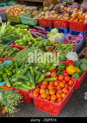 Verdure assortite in cestini colorati in vendita al mercato all'aperto Foto Stock