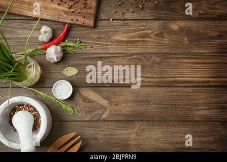 Utensili da cucina, verdure e spezie su sfondo di legno Foto Stock