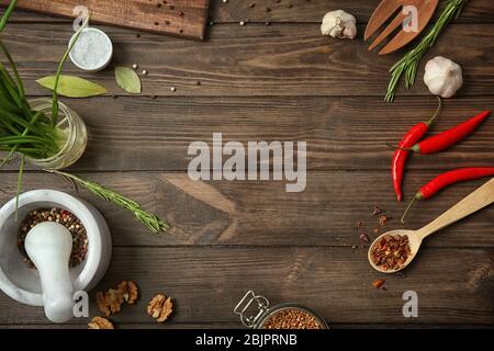 Utensili da cucina, verdure e spezie su sfondo di legno Foto Stock