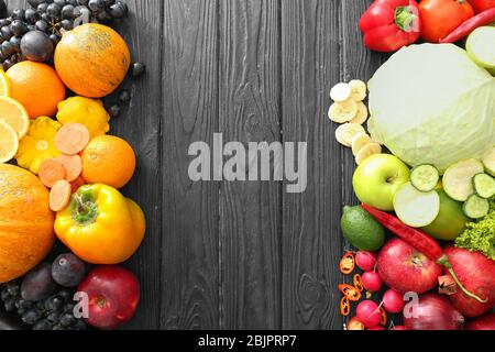 Frutta e legumi vari su sfondo di legno Foto Stock