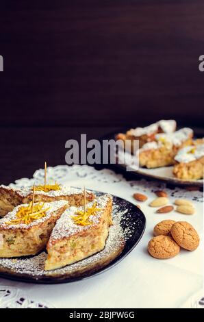 Torta di riso - dessert italiano classico. Torta di riso con mandorle, bucce d'arancia candite e amaretto. Una fetta di torta di riso con biscotti alle mandorle in una p Foto Stock