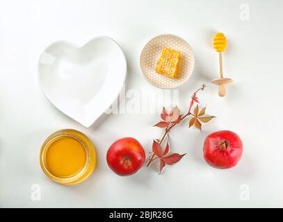 Composizione con miele, mela e melograno per Rosh Hashanah vacanza su sfondo bianco, vista dall'alto Foto Stock