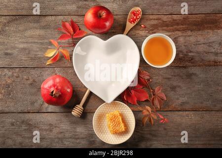 Composizione con miele, mela e melograno per Rosh Hashanah vacanza su sfondo legno, vista dall'alto Foto Stock