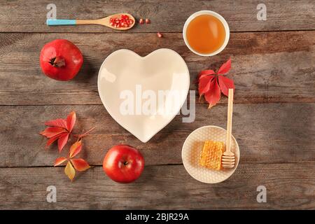 Composizione con miele, mela e melograno per Rosh Hashanah vacanza su sfondo legno, vista dall'alto Foto Stock