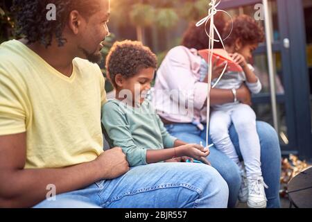 La famiglia africana trascorre il tempo insieme, parla, sorride, gioca, fa un buon tempo. Famiglia, tradizionale, insieme, concetto Foto Stock