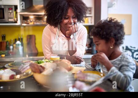 madre e figlia al tavolo da pranzo, parlando, sorridente. Famiglia, insieme Foto Stock