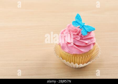 Bellissimo cupcake su sfondo di legno chiaro Foto Stock