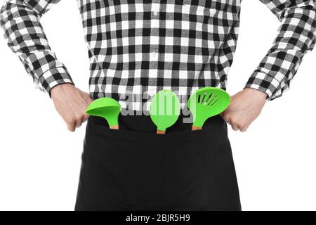 Giovane uomo con utensili da cucina, isolato su bianco Foto Stock