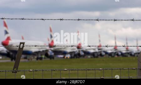 Glasgow, Regno Unito. 30 Aprile 2020. Nella foto: Le nuvole tempesta si riuniscono mentre gli equipaggi di terra della British Airways assistono alla raccolta di 14 aeromobili Airbus A319/A320 e A321 collegati a terra che sono stati parcheggiati sulla seconda pista dell'aeroporto di Glasgow dall'inizio del blocco Coronavirus (COVID-19). Da allora, l'industria globale delle compagnie aeree è andata in tracollo con alcune compagnie aeree che vanno in fallimento e altre come BA che chiedono assistenza finanziaria al governo. Ad oggi BA ha annunciato che è axing quasi 12,000 personale. Credit: Colin Fisher/Alamy Live News Foto Stock