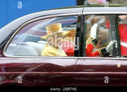 Una sorridente e sventolante regina Elisabetta II vestito di giallo e il duca di Edimburgo guida per l'Abbazia lungo il Mall e nella Parata delle Guardie a Cavallo Foto Stock