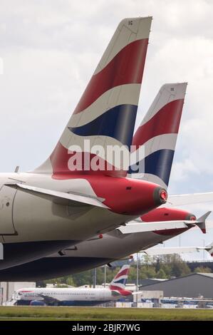 Glasgow, Regno Unito. 30 Aprile 2020. Nella foto: Le nuvole tempesta si riuniscono mentre gli equipaggi di terra della British Airways assistono alla raccolta di 14 aeromobili Airbus A319/A320 e A321 collegati a terra che sono stati parcheggiati sulla seconda pista dell'aeroporto di Glasgow dall'inizio del blocco Coronavirus (COVID-19). Da allora, l'industria globale delle compagnie aeree è andata in tracollo con alcune compagnie aeree che vanno in fallimento e altre come BA che chiedono assistenza finanziaria al governo. Ad oggi BA ha annunciato che è axing quasi 12,000 personale. Credit: Colin Fisher/Alamy Live News Foto Stock