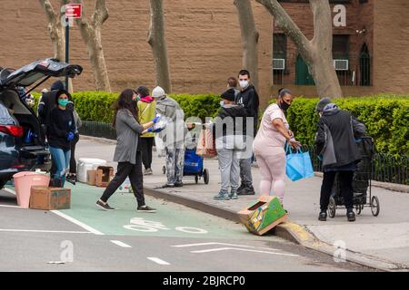 I volontari evangelici di Chelsea a New York distribuiscono cibo sabato 25 aprile 2020. Con 26 milioni di persone che chiedono disoccupazione, i panico alimentari sono diventati un’ancora di salvezza per molti. (© Richard B. Levine) Foto Stock
