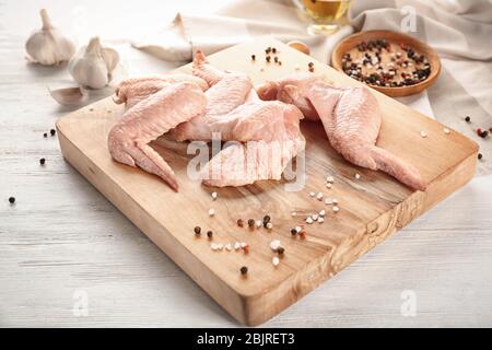 Tavola di legno con materie di ali di pollo su tavola Foto Stock