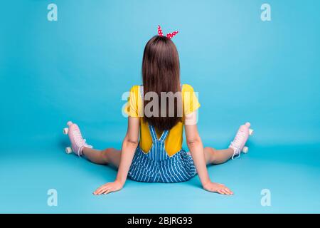 Retro dietro la vista di lei bella ragazza attraente seduta sul pavimento indossando skaters tempo libero vacanza fine settimana isolato su brillante brillante brillante brillante brillante brillante brillante brillante brillante brillante Foto Stock