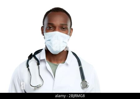 Triste guardare sopra. Giovane medico maschile con stetoscopio e maschera facciale su sfondo bianco studio. Sembra triste, serio. Concetto di sanità e medicina, coronavirus pandemico, epidemia di pericolo, COVID. Foto Stock
