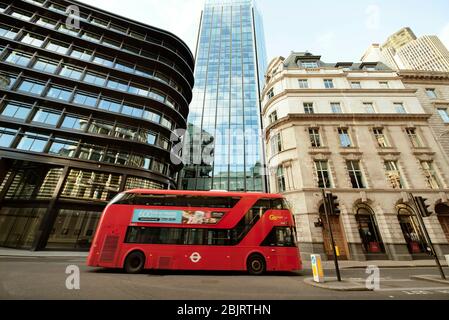 La città di Londra (Threadneedle Street / Old Broad St). Scatto architettonico grandangolare con autobus vuoto che passa la strada durante la chiusura. Mar 2020 Foto Stock