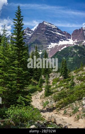 Majestic Maroon Bells picchi visti dal robusto Crater Lake Trail in una giornata di sole con cielo blu in estate vicino a Aspen Colorado Foto Stock