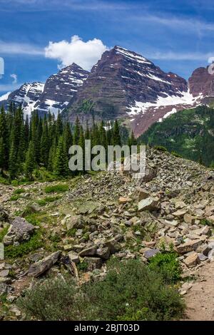 Majestic Maroon Bells picchi visti dal robusto Crater Lake Trail in una giornata di sole con cielo blu in estate vicino a Aspen Colorado Foto Stock