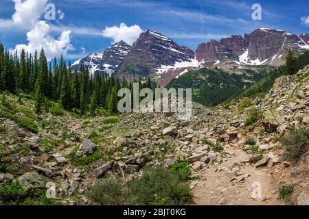 Majestic Maroon Bells picchi visti dal robusto Crater Lake Trail in una giornata di sole con cielo blu in estate vicino a Aspen Colorado Foto Stock