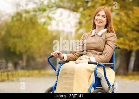 Giovane donna in sedia a rotelle all'aperto Foto Stock