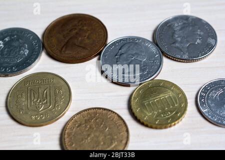 monete di paesi diversi numismatica su un tavolo di legno chiaro. vista laterale. per chiudere Foto Stock