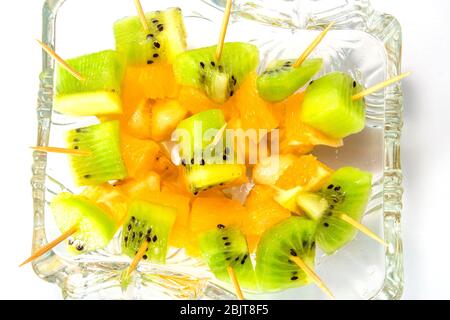 utili tartine di frutta da banana arancione e kiwi in un bicchiere di cibo per il fitness su sfondo bianco. spazio per la copia Foto Stock